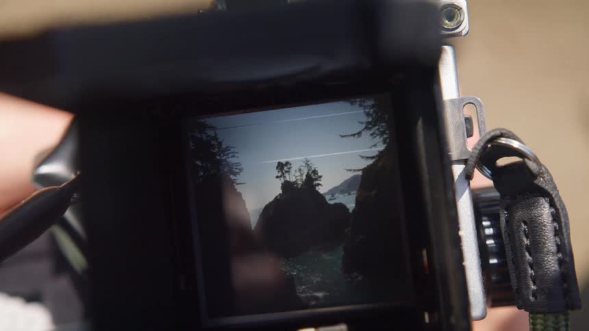 The screen of a camera displaying an islet off the coast on a sunny day
