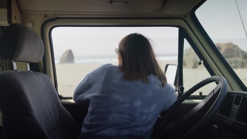 A woman sitting in the car takes the key out of the ignition