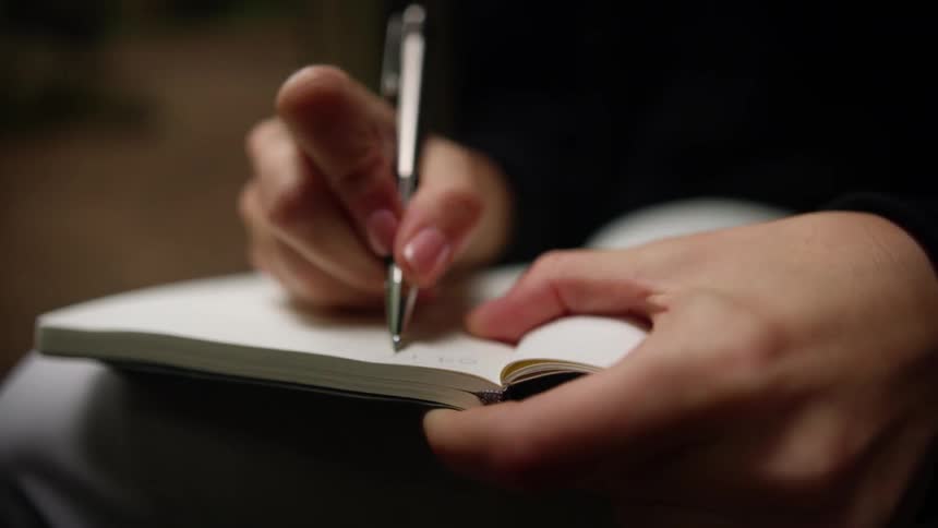 A person is writing in their notebook