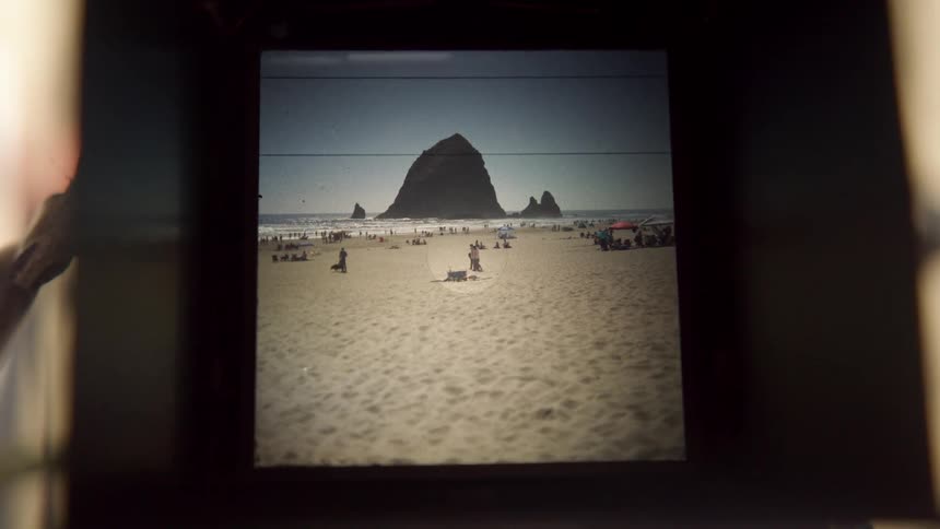 A camera showing a beach with sand with the sky and clouds in the background