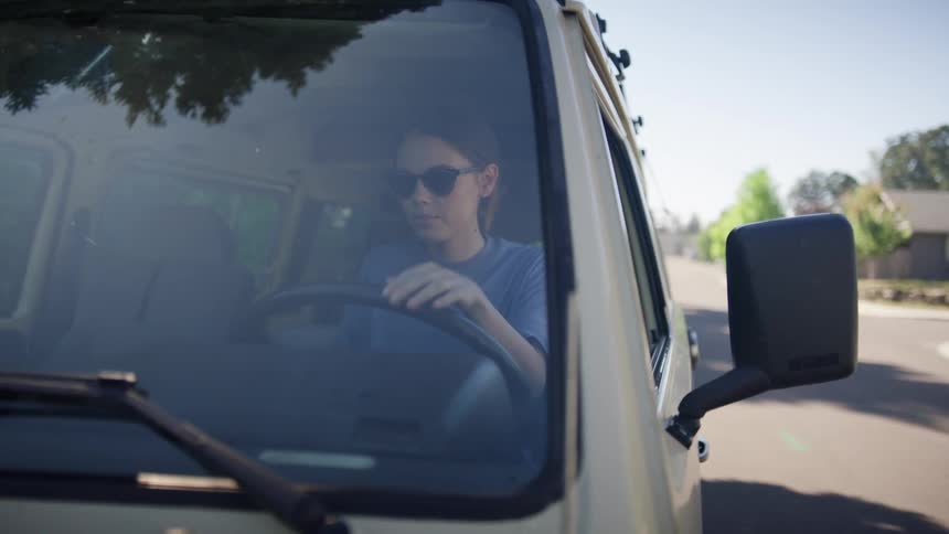 Woman wears sunglasses and starts the van