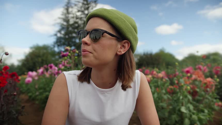 A woman is sitting outdoors by some flowers in spring