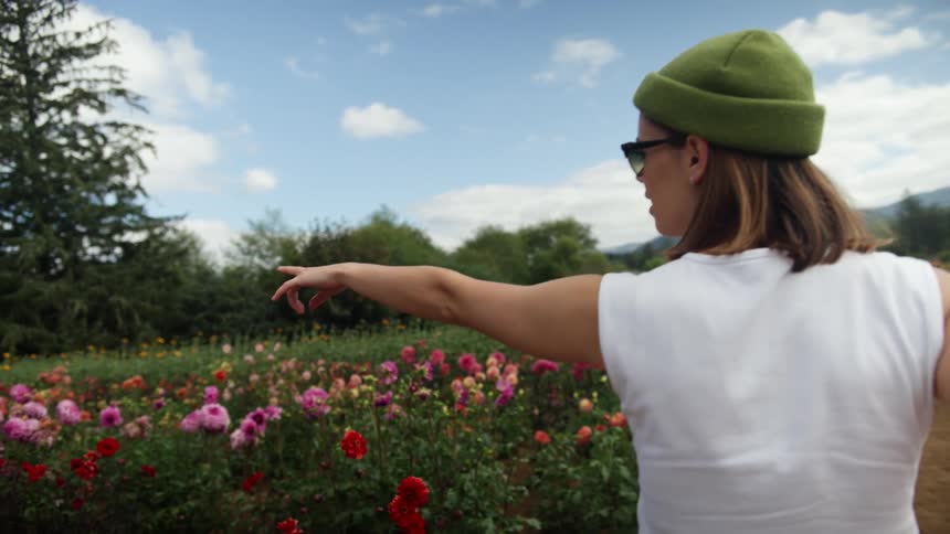 A woman is walking down a meadow in spring