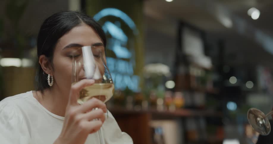 A group of friend at a bar clink their glasses together as they toast