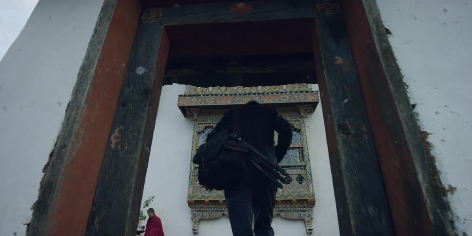 A man is climbing some steps towards a building