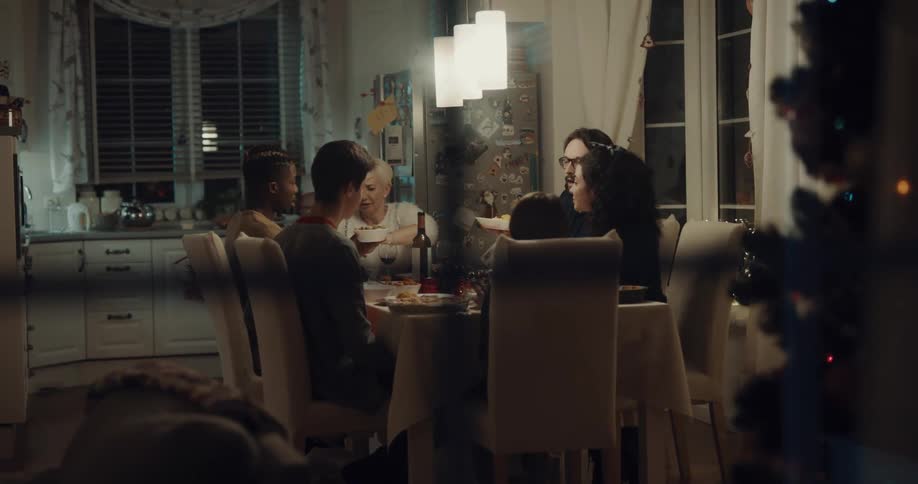 The family inside is having dinner together