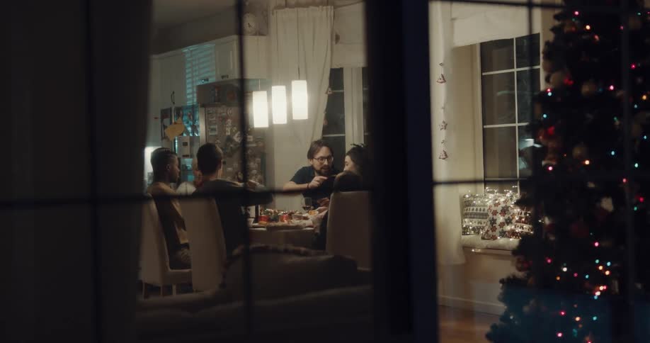 A family sits and eats a meal in their home