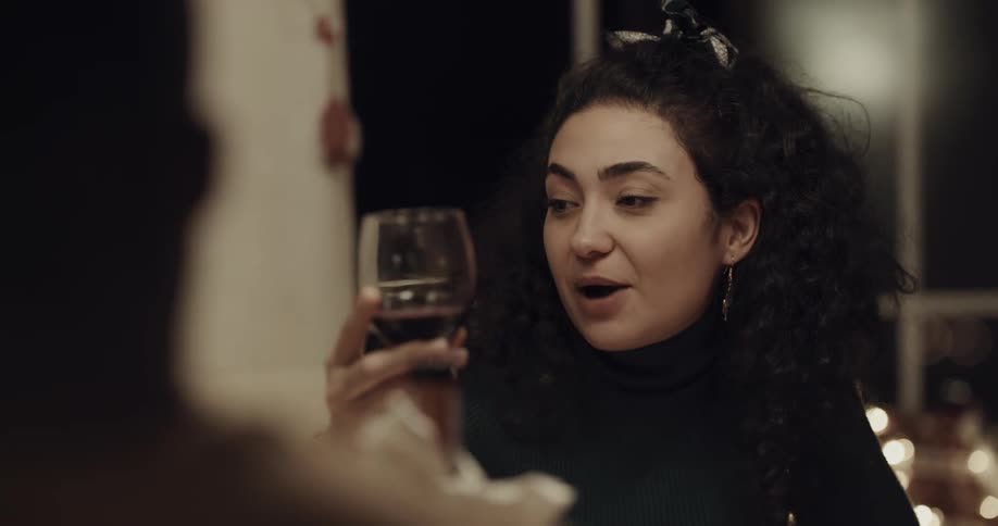 Woman has glass filled with wine then shares a toast with friends