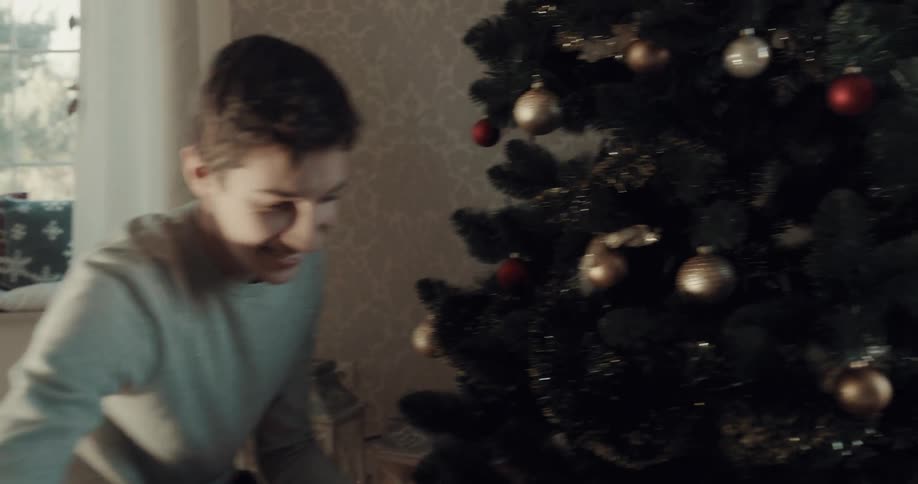 Two brothers race to christmas tree with boxes of decorations smiling