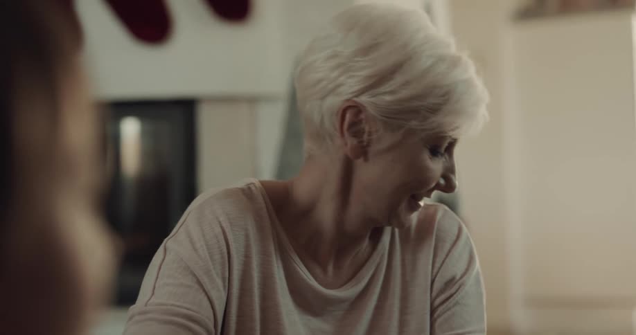 A woman inside her home talks and laughs with others