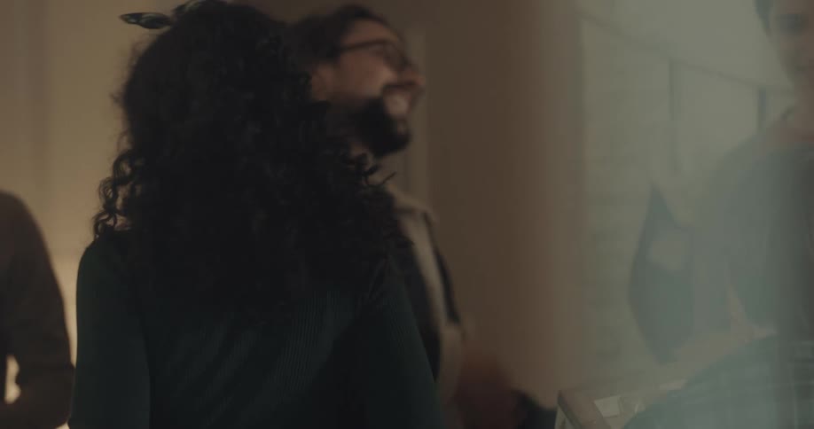 A group of people greet each other inside of a house on christmas