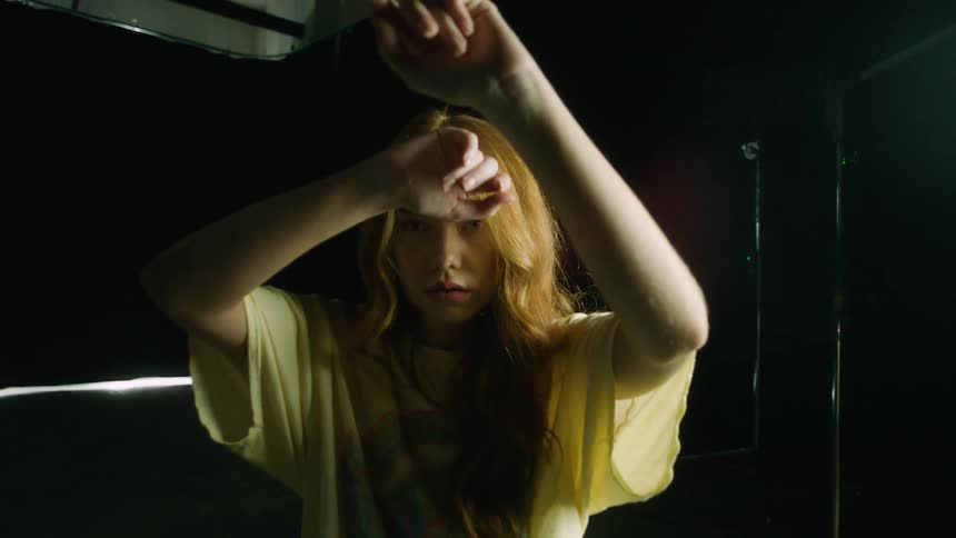 A caucasian woman moving her arms in front of her and posing for the camera