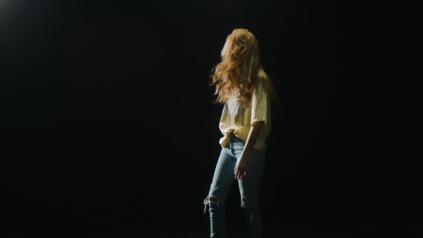 A girl shakes her head flipping her hair