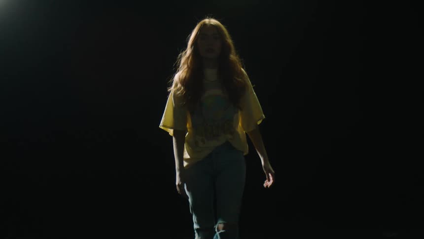 A woman is walking outdoors at night