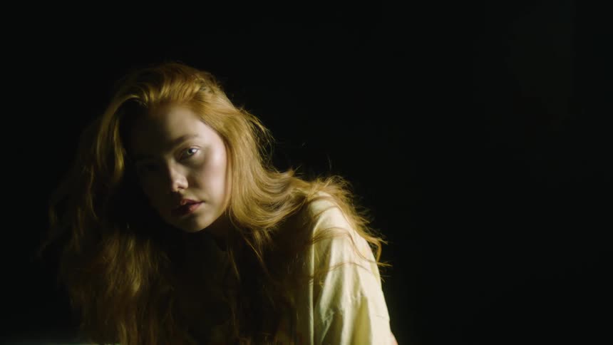 A girl leans forward and looks at the camera