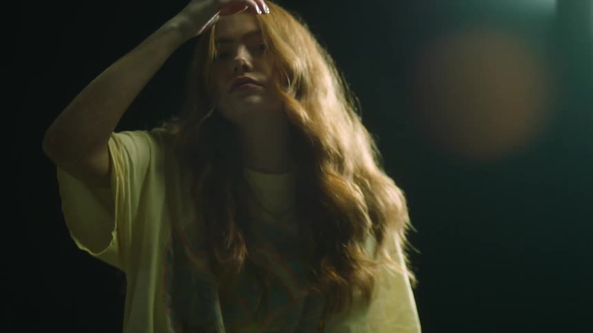 A woman is standing in a room at night
