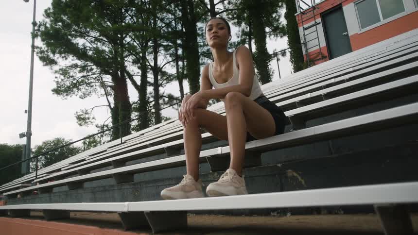 A woman sits on bleachers in a stadium