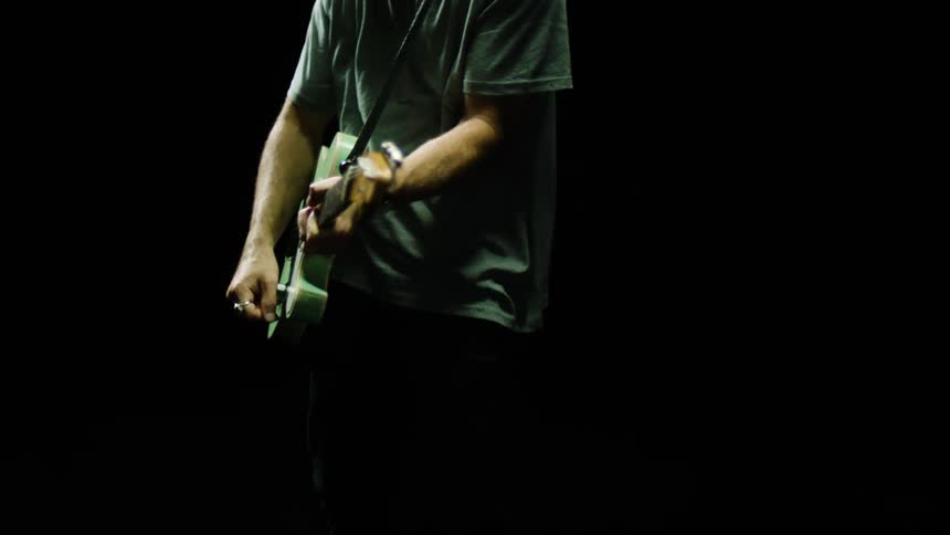 A man is playing a guitar at night