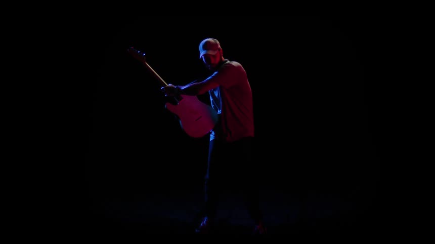 A man is playing the guitar at night