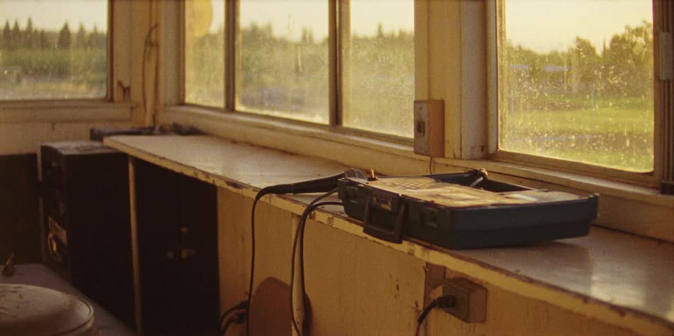 A microphone sits in a press box with the sun coming through windows