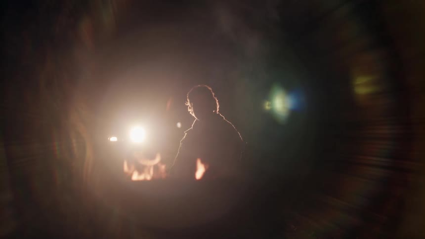 A person is sitting by the campfire