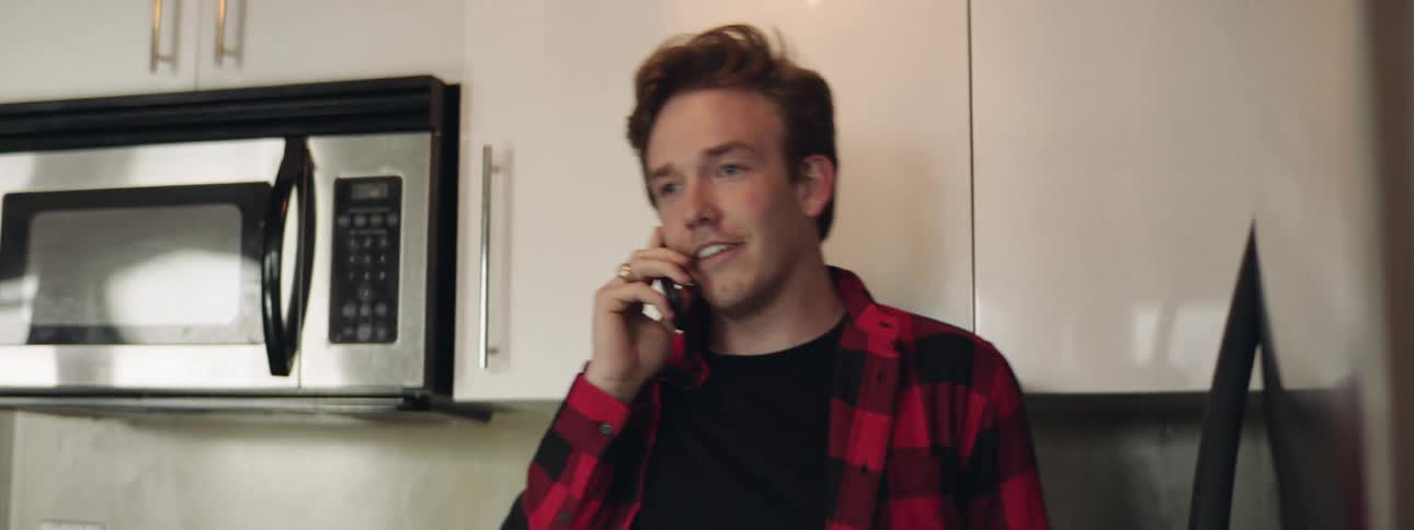 A man is talking on his cell phone indoors