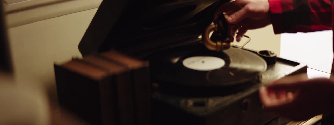 A woman puts a record on a vintage record player