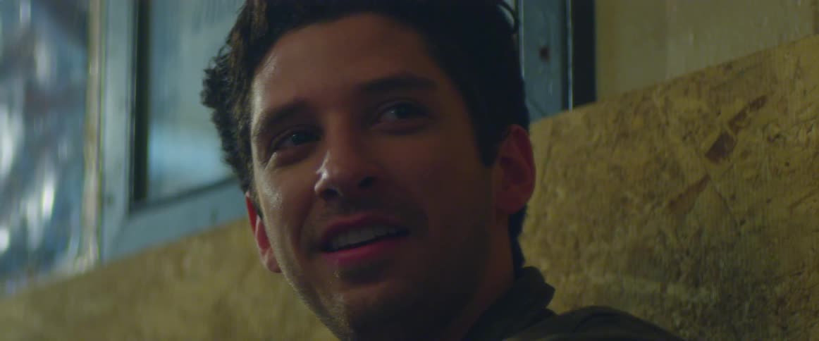 A man stares off looking at something with a smile on his face contemplating what someone might be saying