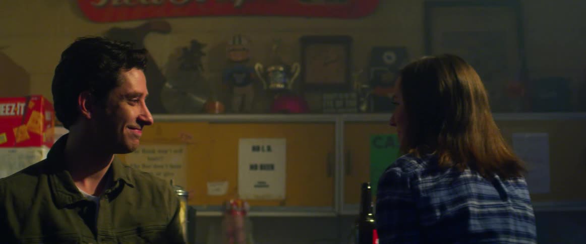 A man is walking in a bar and shakes the hand of a woman at the bar