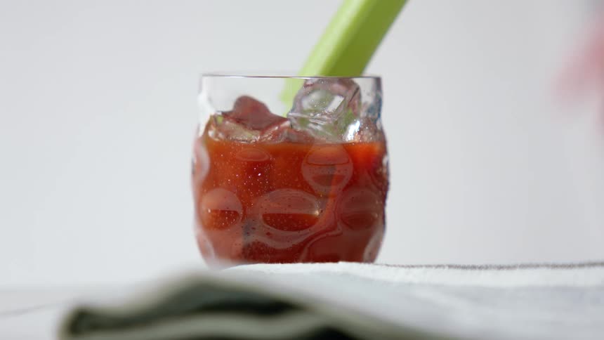Person sets bloody mary down on cloth and back away