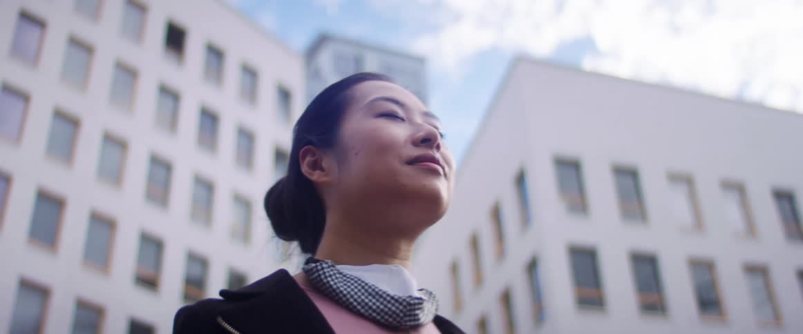 A woman is standing in an urban city