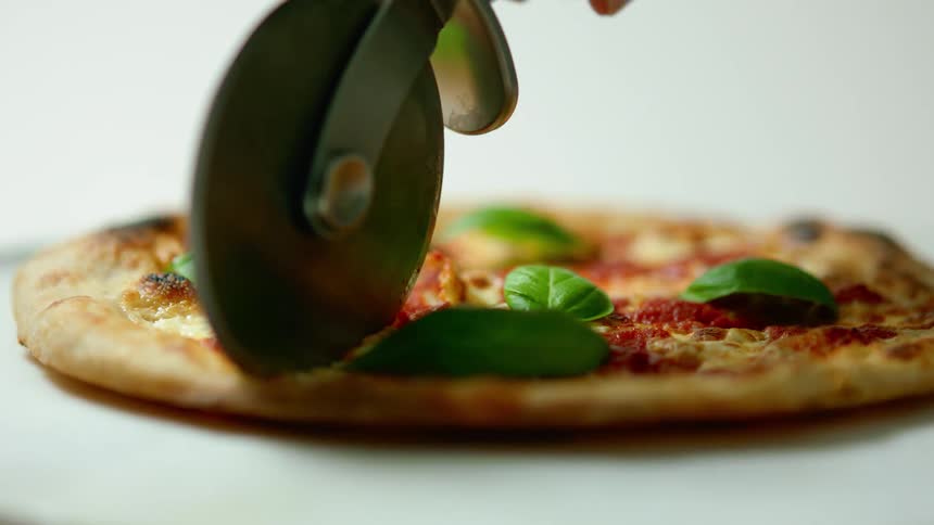 A person is cutting a pizza