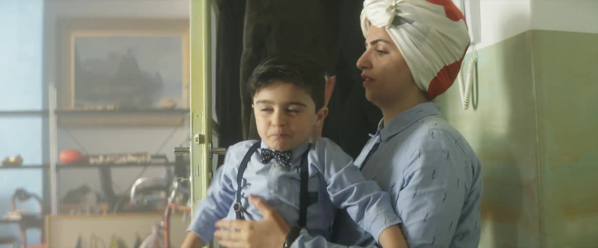 A young boy runs into his home and his mothers arms as she combs his hair
