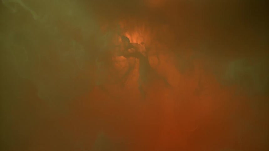Lights shining behind swirling orange liquid