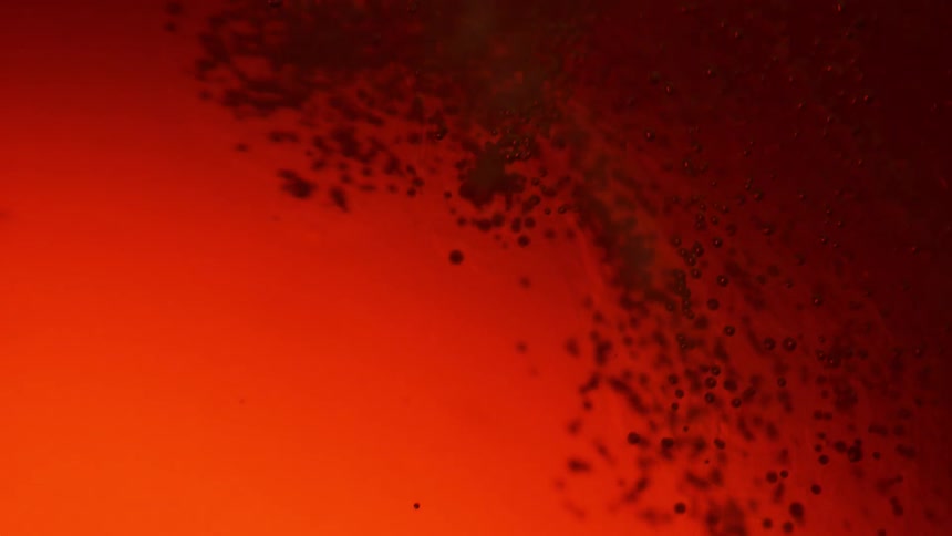 Swirling red liquid in darkness