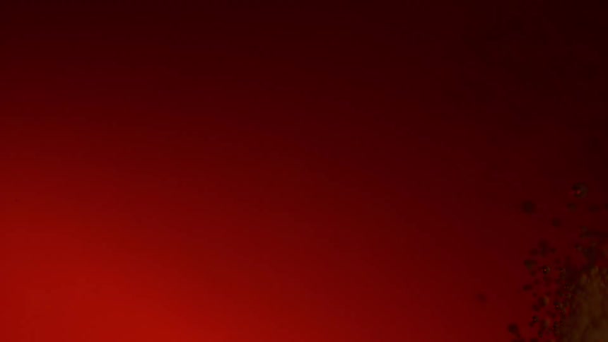 A red powder dye explodes and expands in liquid