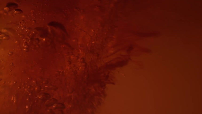 Bubbles spraying under orange liquid