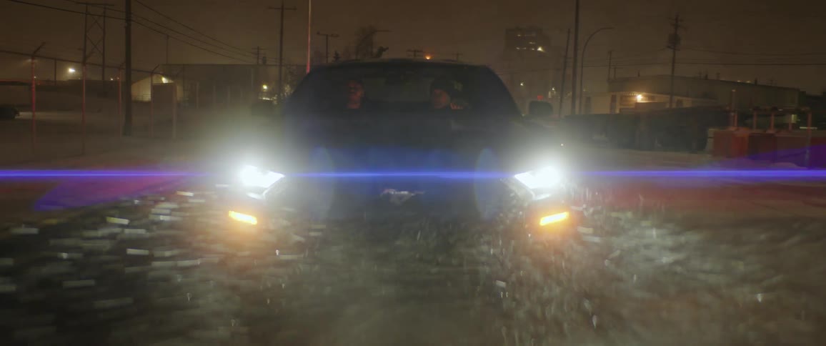 A car is driving down a road in winter