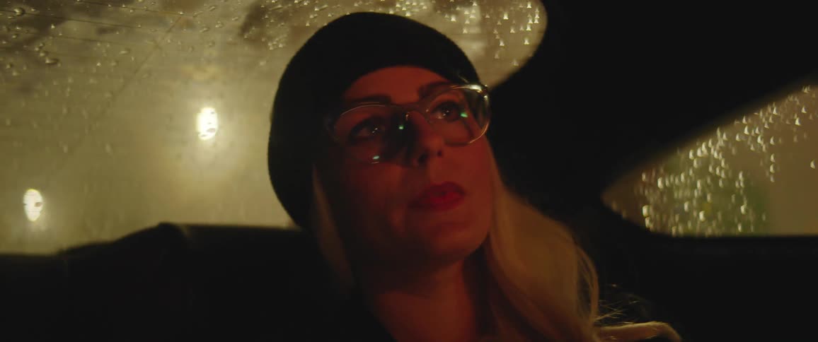 A woman is in a car at night