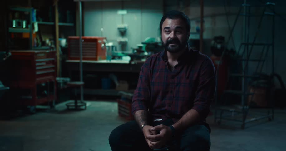 A man is sitting in agarage at night