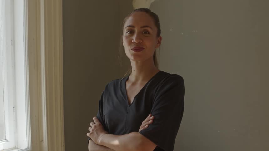 A woman is smiling inside a room