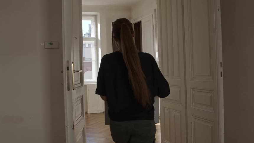 A woman carries a box in to a house