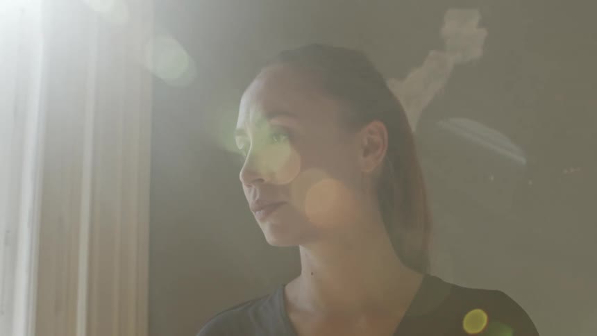 A woman is looking out a window during the day