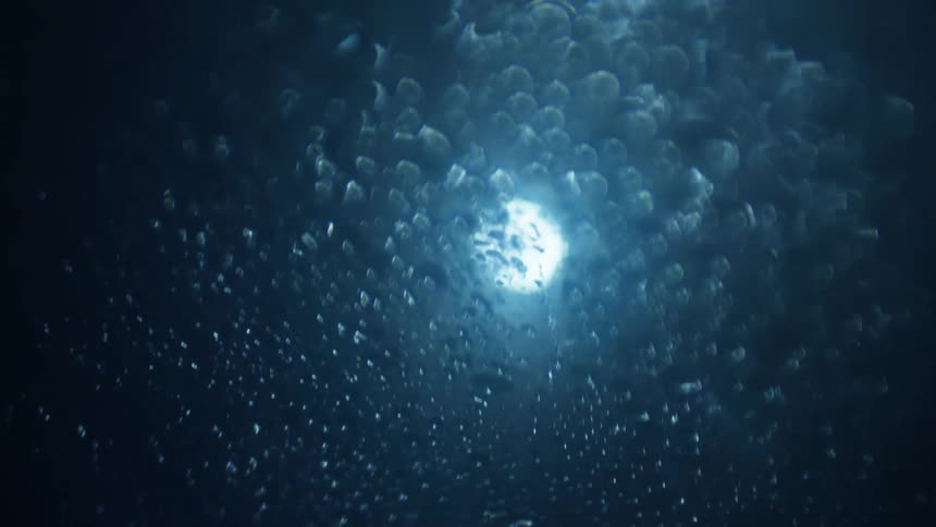 Water droplets covering a piece of glass in the dark