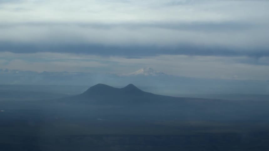 Snowy mountains in the distance on a cloudy foggy day