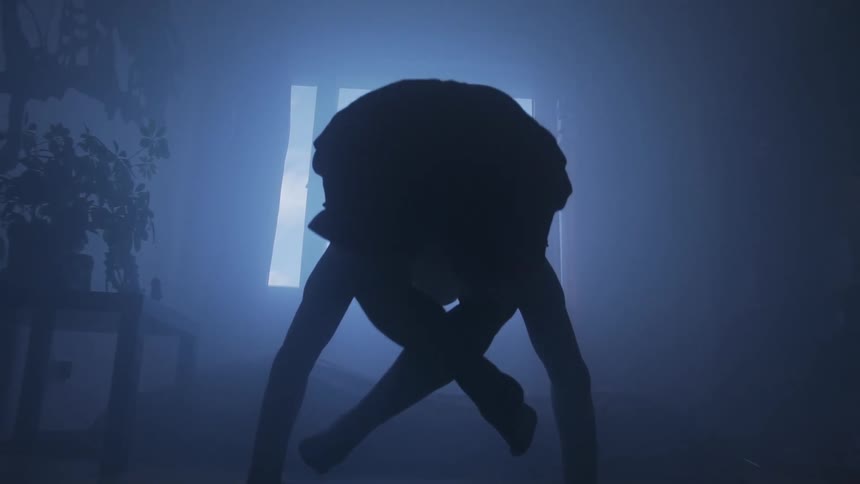 A woman doing yoga moves into a handstand pose and crosses her legs