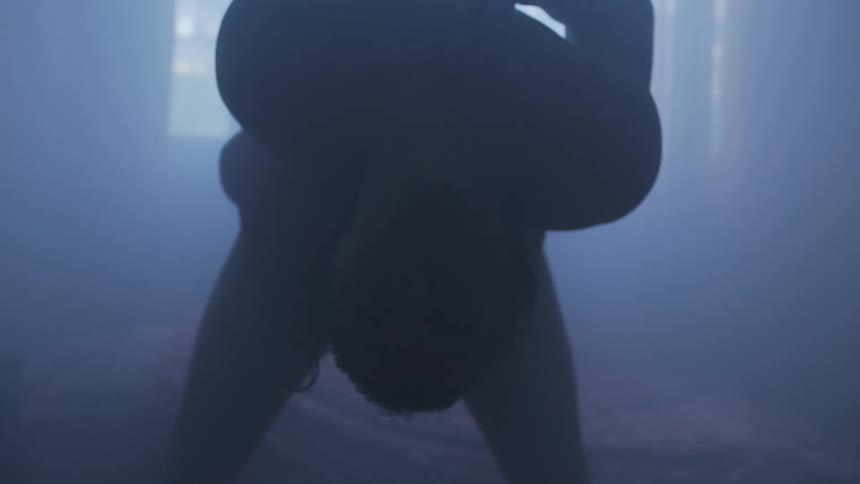 A man is doing yoga in the dark room
