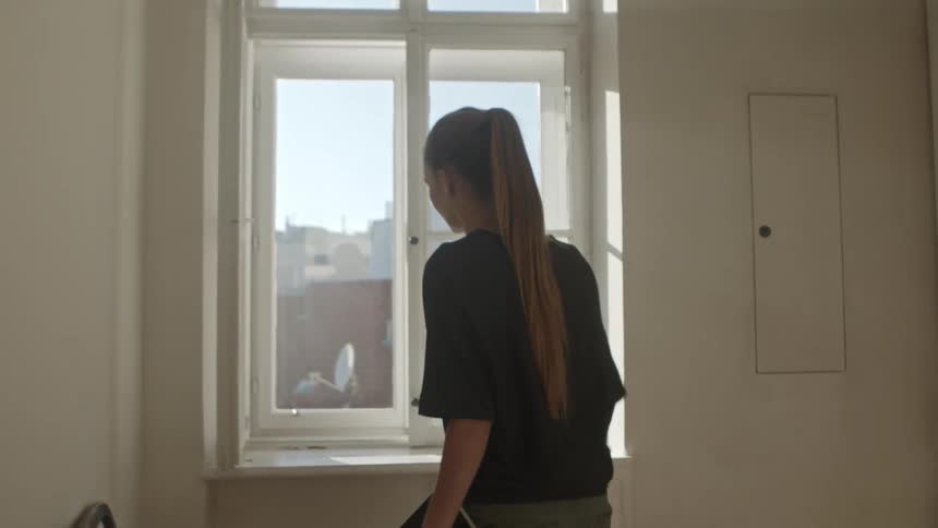 A woman is walking through a house