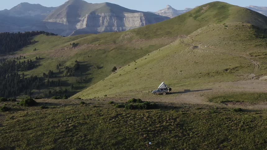 Camera parked on a mountain surrounded by other mountains and a view