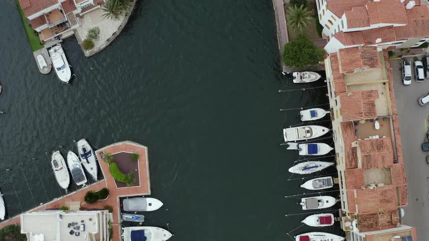 Boats docked along a waterway on the coast of a city during the day